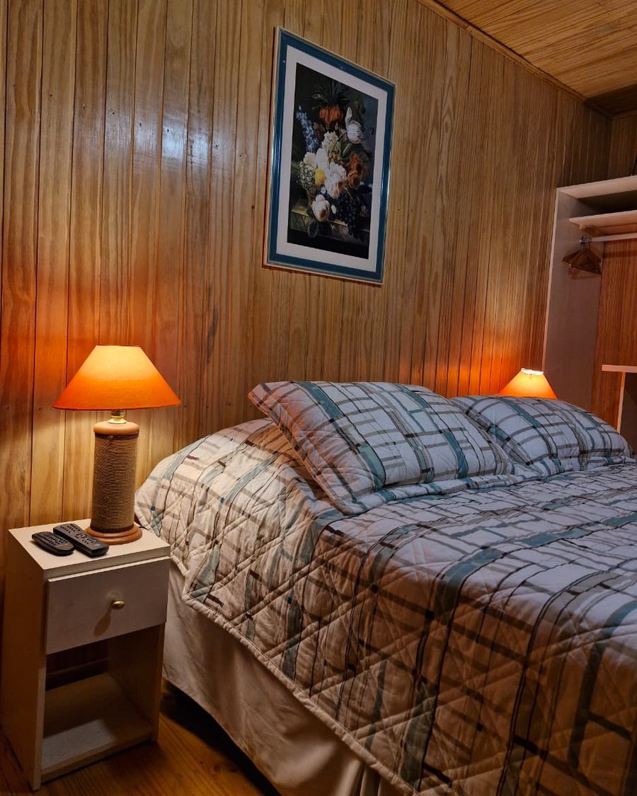 Suíte Pinheiro - cama, criado-mudo e controles