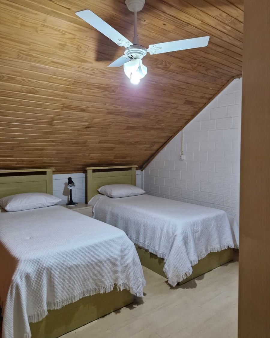 Suíte Mansarda - camas, ventilador e parede branca
